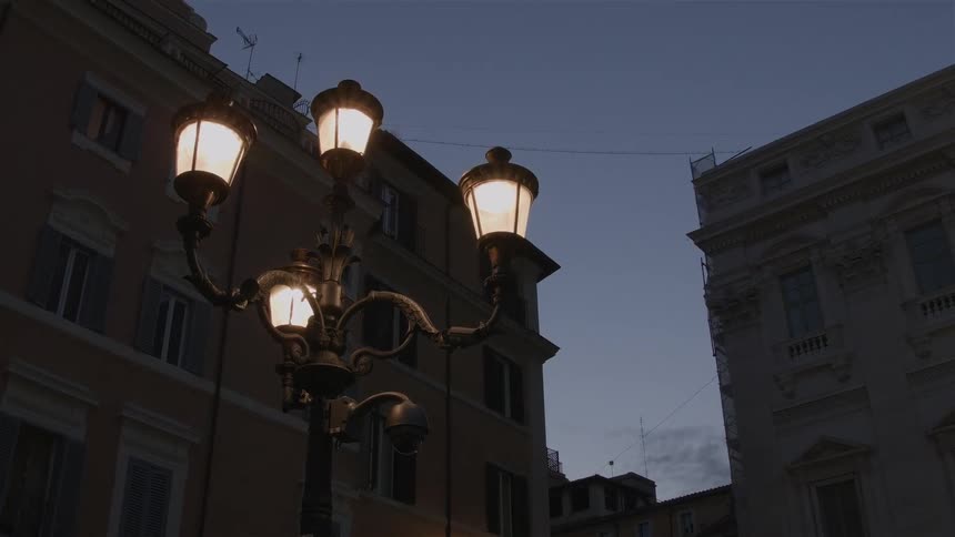 A lamp post glows in a city at night