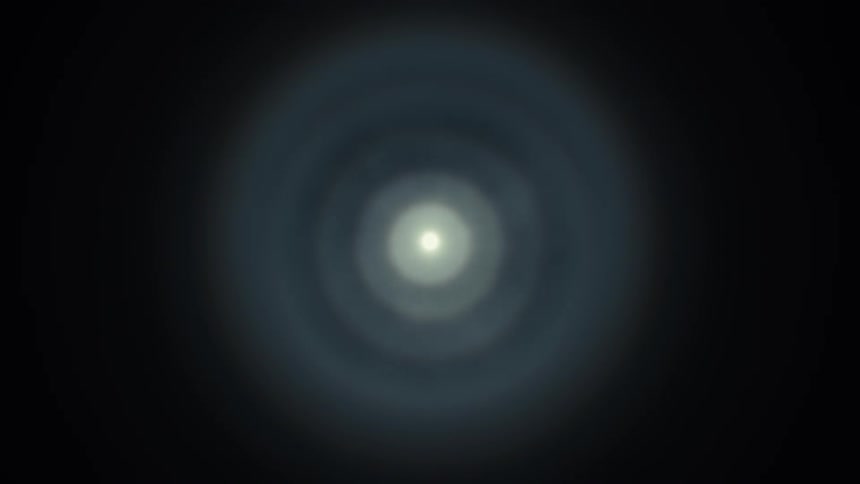 A bright, ethereal light pulses at the end of a dark, abstract tunnel, creating a hypnotic effect