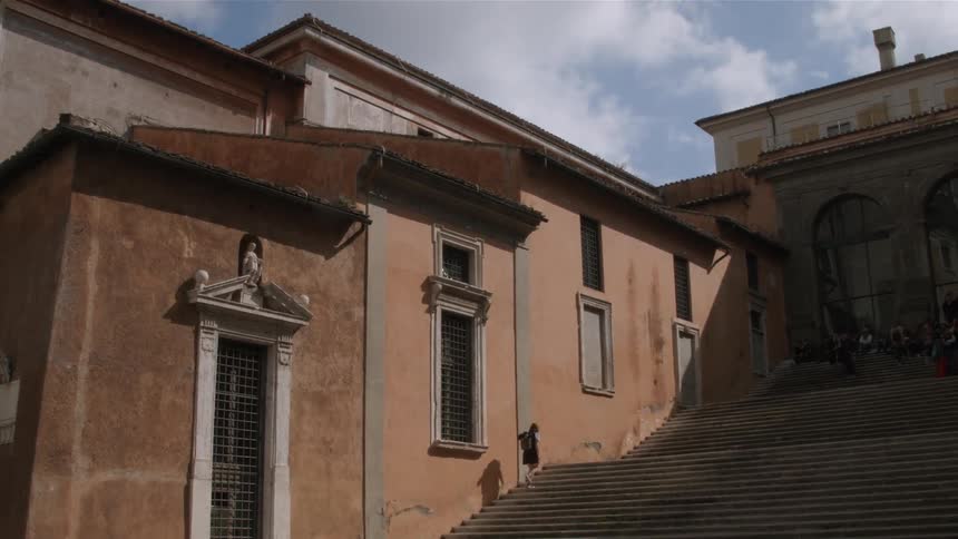 Person walks up a large staircase outside of a building