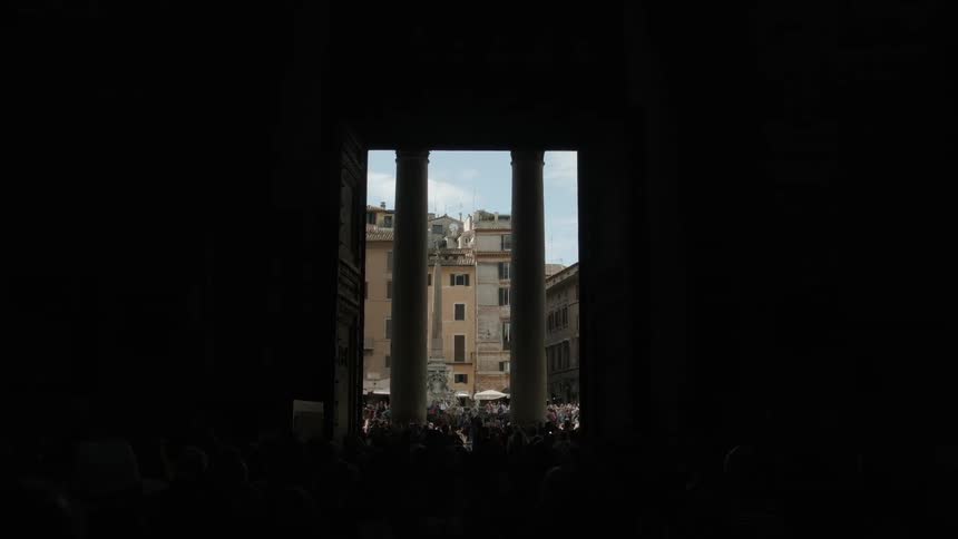 Past these two pillars is a large crowd of people
