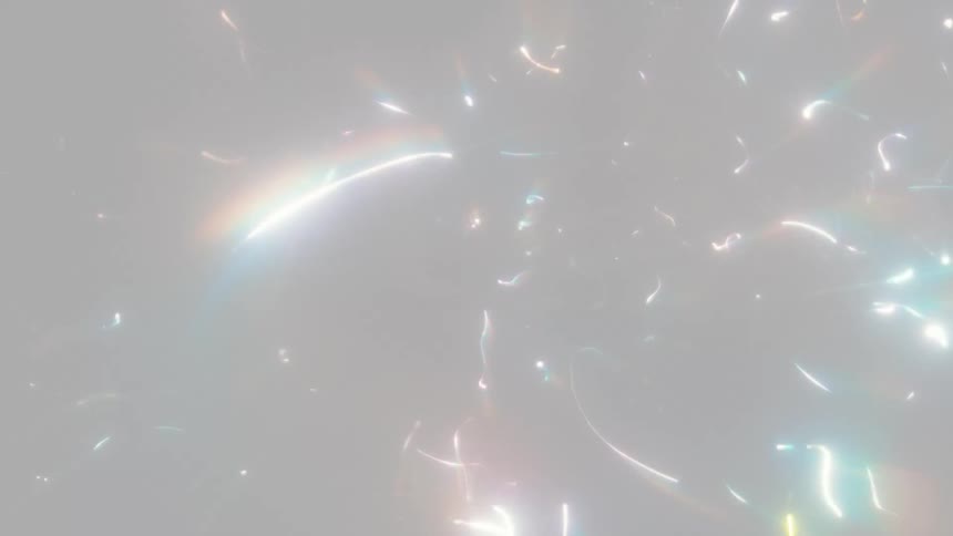 An ethereal abstract background of swirling rainbow-colored light streaks and glowing particles