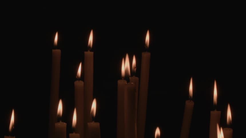 A group of candles are lit in a dark room