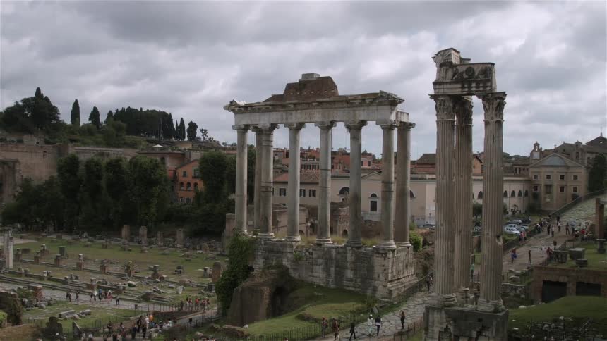 People walk beneath ancient columns