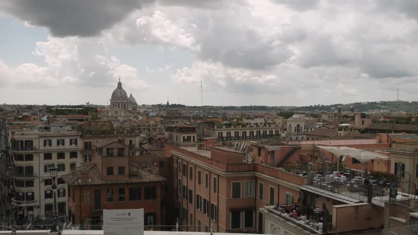 Clouds hover over the rooftops of an old city