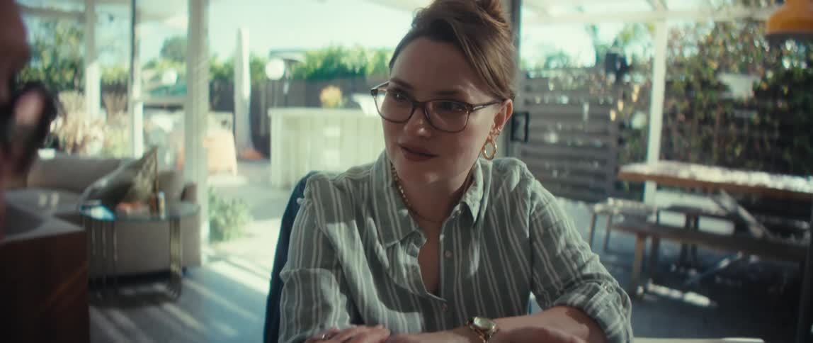A compassionate financial advisor carefully explains a document with charts to a senior woman in a bright, modern home