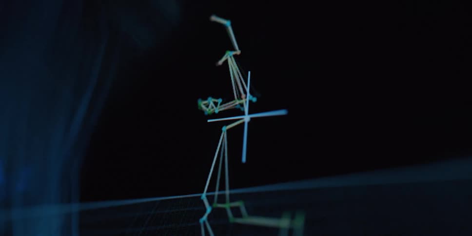 A close-up of a computer screen displays a 3D wireframe animation of a walking figure for motion capture analysis