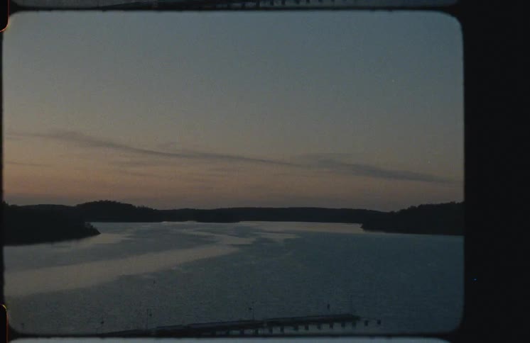 A peaceful view of a wide body of water at dusk, shot on authentic vintage film