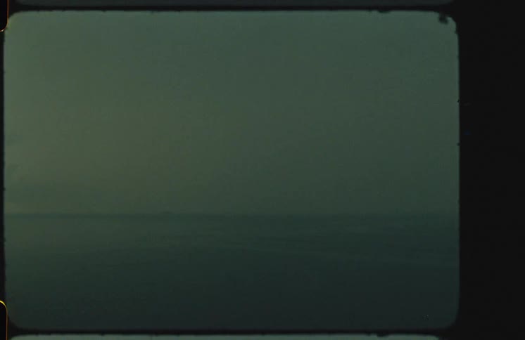 Grainy super 8 footage of a dark, misty ocean horizon