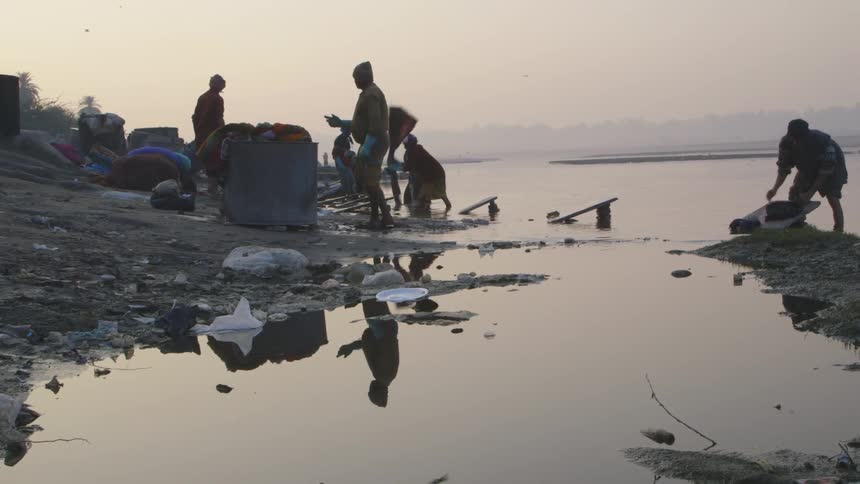 People wash laundry in a river