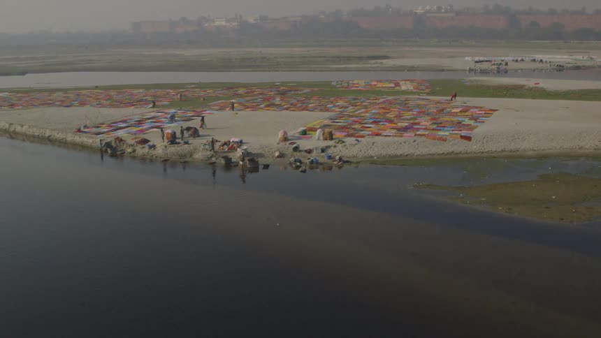 Many patches of color on the ground beside water