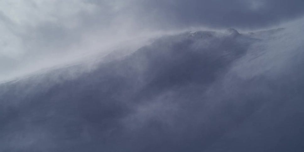 Close up of a fierce blizzard with strong winds blowing snow across a mountain ridge