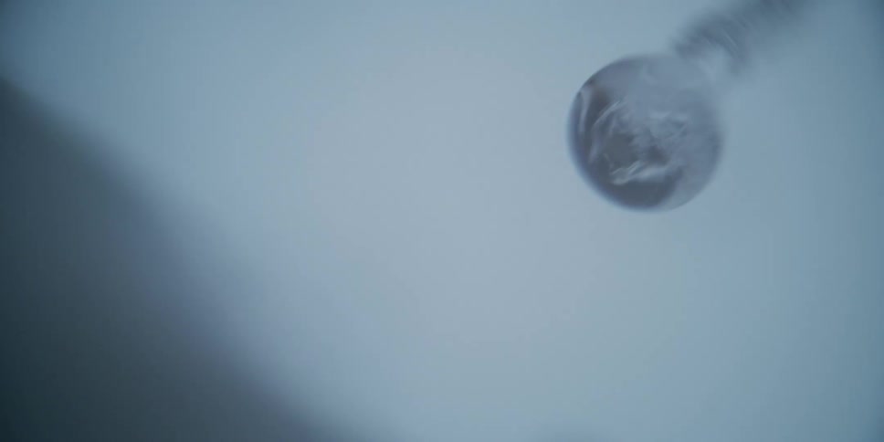 A mysterious white vapor swirls inside a glass bulb in this abstract macro shot