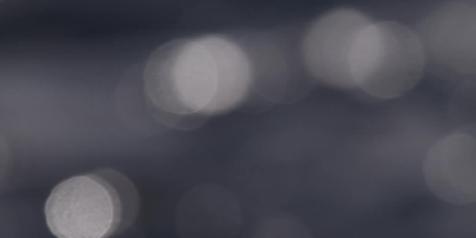 Slow, out-of-focus monochrome light reflections create a dreamy and abstract bokeh background