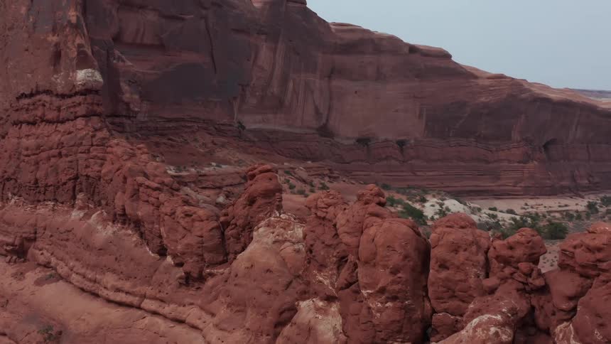 A slow aerial reveal shot of the vast red rock canyon and desert landscape at Arches National Park
