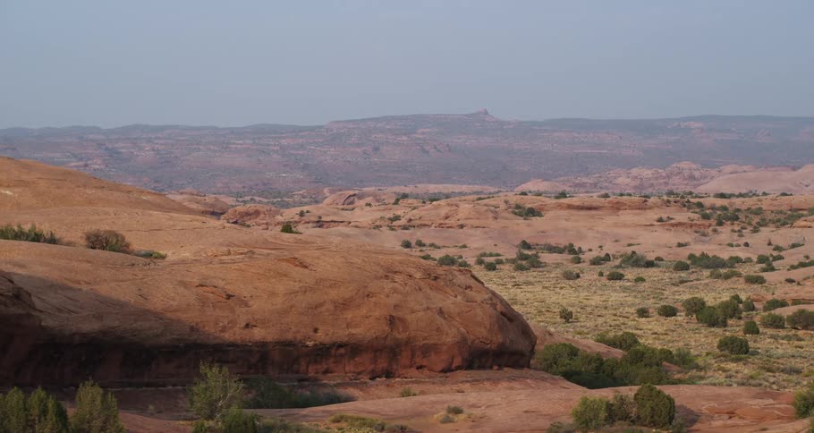 A slow pan across the vast and rugged red rock desert landscape of southern Utah