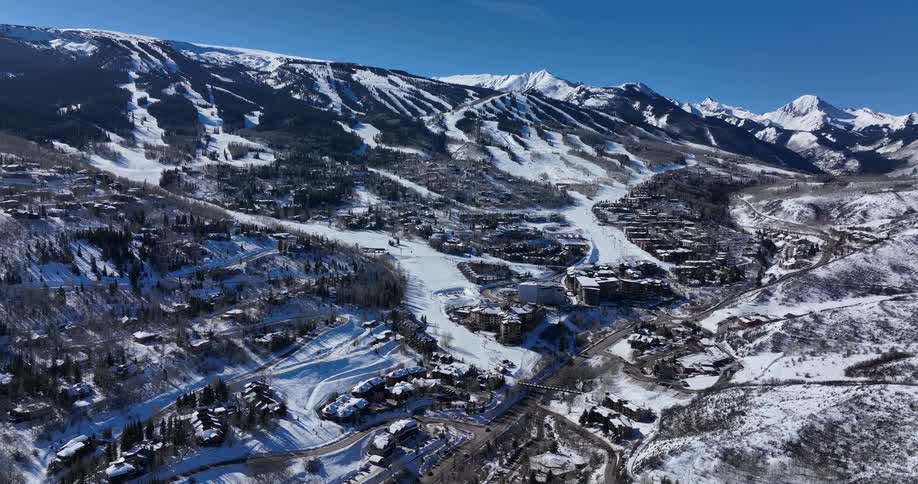 A static aerial view of the expansive Snowmass ski resort in Colorado on a bright, sunny winter day