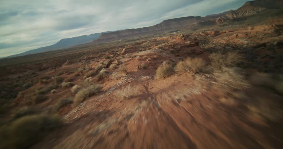 An immersive first-person perspective captures a high-speed journey along a dusty ridge in the desert