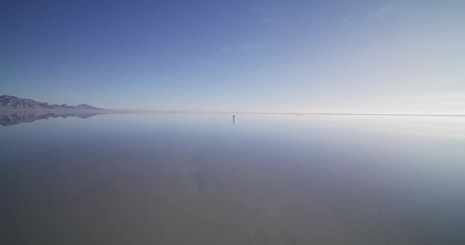 A slow aerial flyover reveals a mysterious monolith emerging from the mirror-like waters of the Bonneville Salt Flats