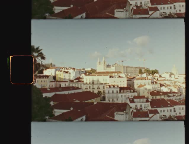 A vintage film strip scan of the sunlit, red-roofed cityscape of Lisbon, Portugal