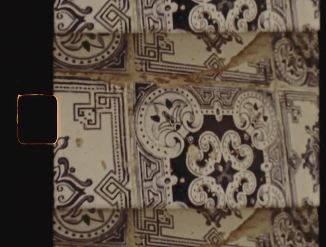 A slow pan across weathered, antique blue and white ceramic tiles featuring ornate, traditional patterns