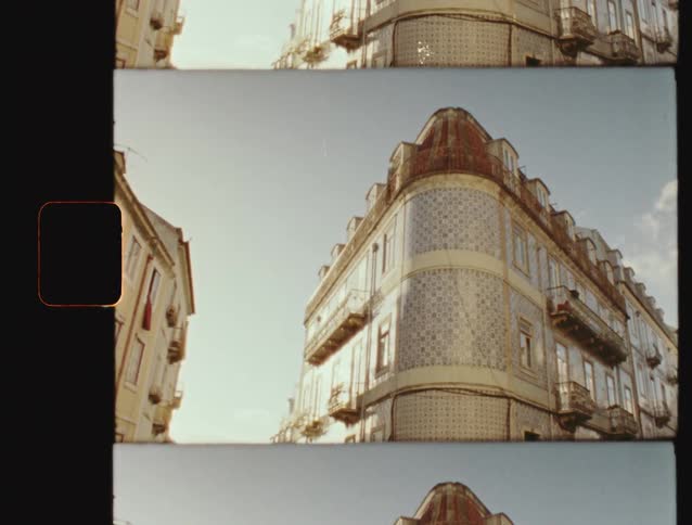 A vintage film scan shows a low-angle, static shot of a beautiful building with traditional Portuguese Azulejo tiles