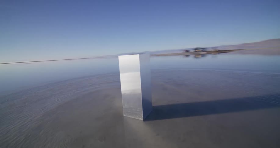A mysterious metal monolith stands in the surreal, reflective landscape of the Bonneville Salt Flats as the camera orbits it