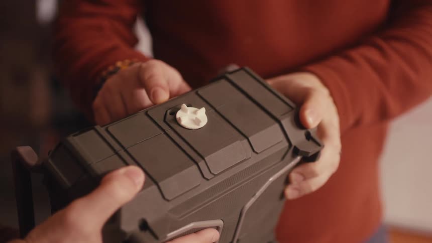 Close up shot of a man's hands turning a white knob on a futuristic sci-fi device