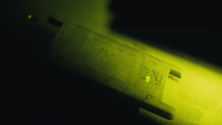 Detailed macro shot of a laser beam sintering a part during the 3D printing process