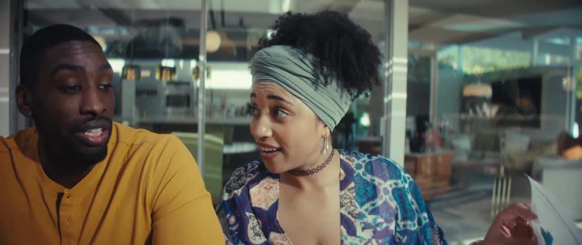A slow upward reveal shows a diverse couple discussing business plans, reviewing charts, and using a calculator in a modern setting