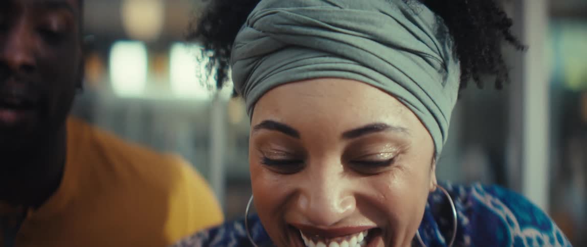 A slow reveal shows a happy couple smiling and laughing while looking at a laptop computer together
