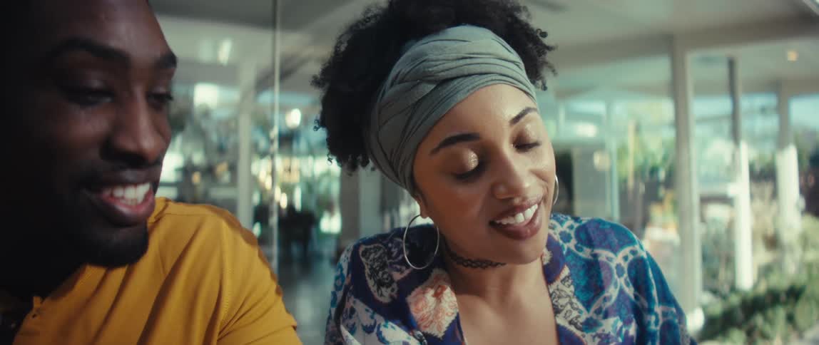 Close-up slow motion shot of a young Black couple happily working on their finances together at home, using a laptop and calculator