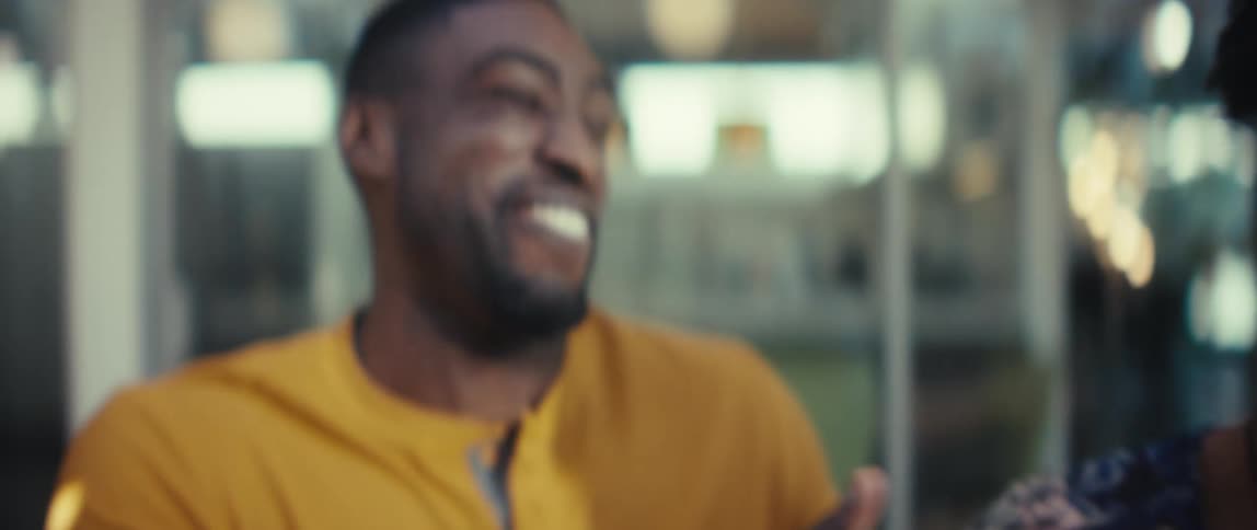 A happy young couple shares a joyful moment, laughing uncontrollably in slow motion while watching something together