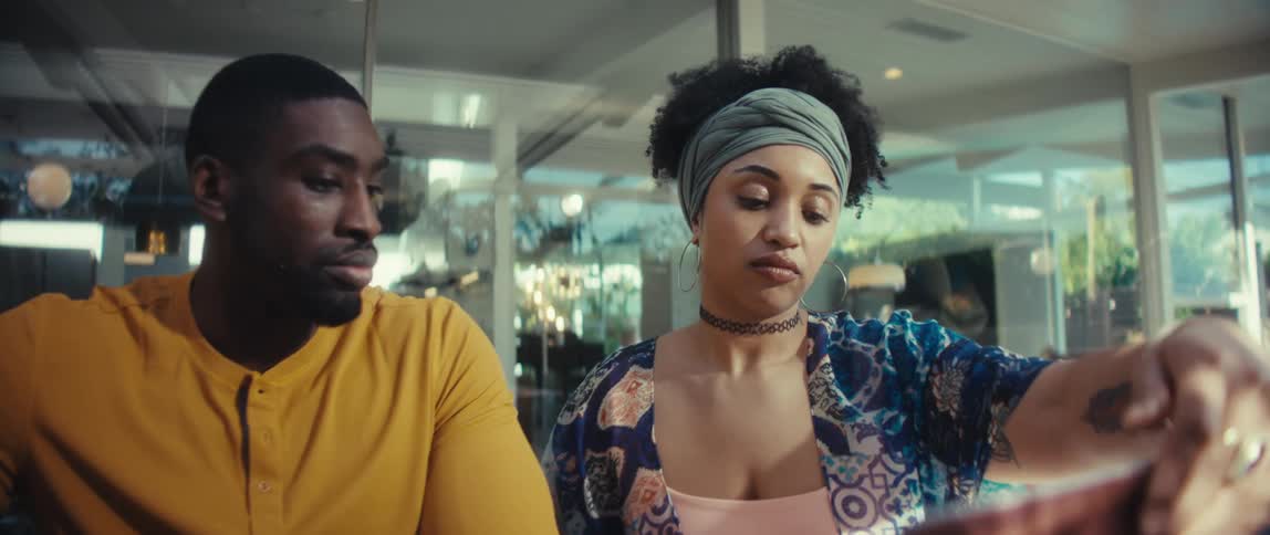 A slow-motion shot of a young couple opening a laptop at their dining table as they begin an important discussion