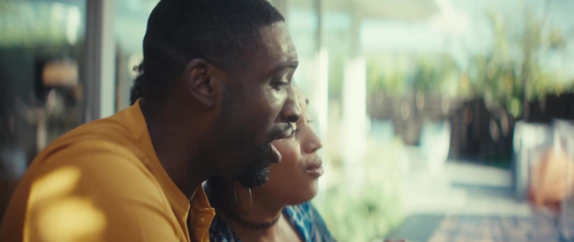 Joyful African-American couple express excitement and surprise while looking at a laptop together at home