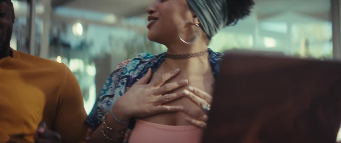 A young woman's face goes from shock to pure joy as she starts dancing ecstatically with her partner
