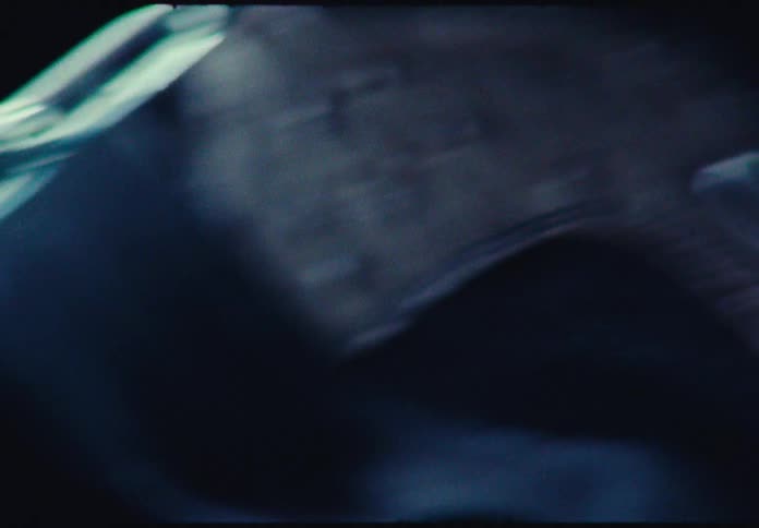 A dreamy, lo-fi close-up of a metal chain draped over a sneaker with a vintage film look