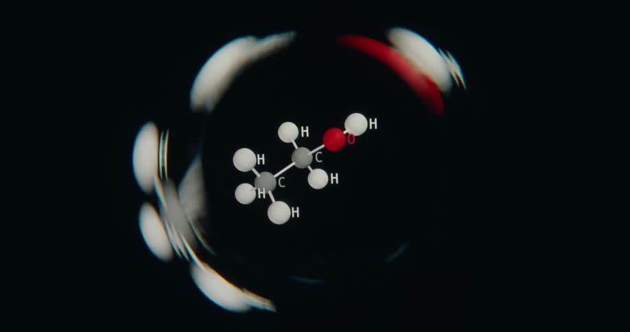 An abstract CGI animation of an ethanol molecule rotating in the center of a distorted circular frame on a black background