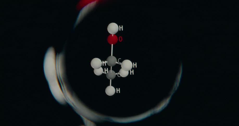 A 3D model of an Isopropanol alcohol molecule rotates against a black background with a visual distortion effect