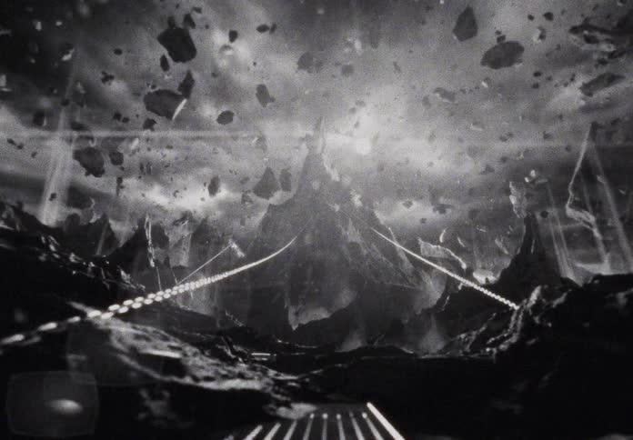 A vintage-style black and white animation shows an apocalyptic alien world with energy beams and floating debris