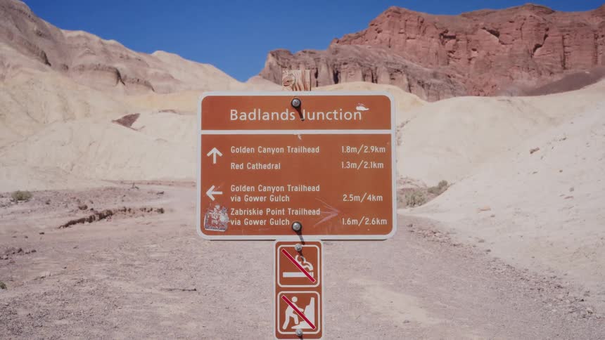 A hiking trail sign at Badlands Junction points the way for adventurers in the arid landscape of Death Valley National Park