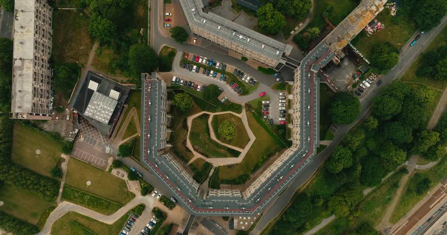 A static top-down aerial shot reveals the unique architectural design of a large residential building complex with a central courtyard
