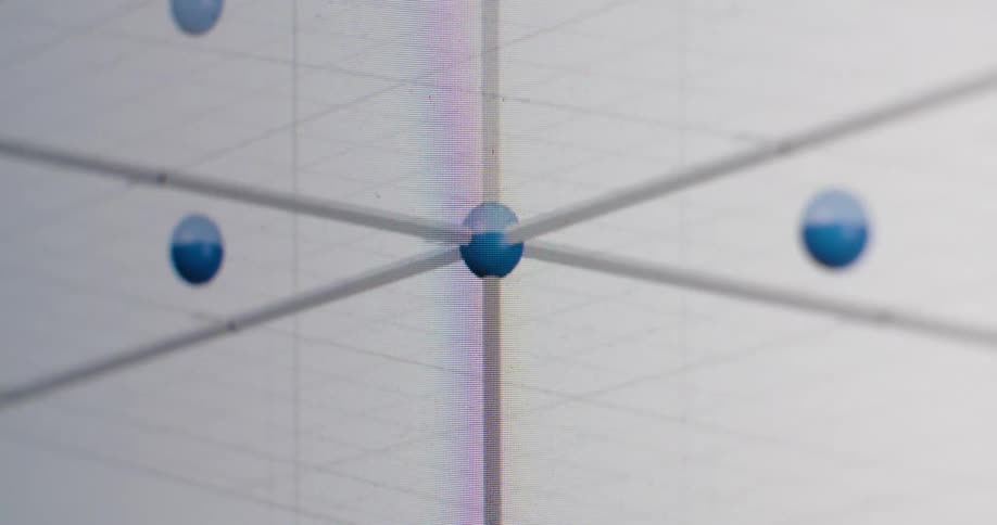 A macro view of an animated 3D scatter plot on a computer monitor, with data points being manipulated