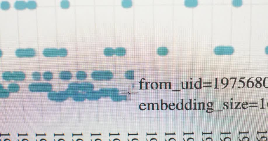 A close-up view of a computer screen shows a mouse cursor moving over lines of code and data points on a digital graph