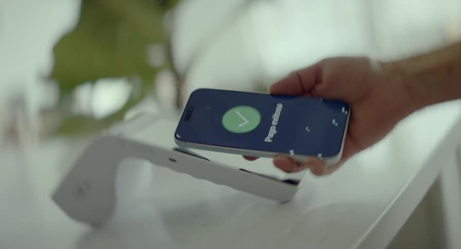 Dynamic rotating close-up of a contactless mobile payment with a 'Pago exitoso' success message on the screen in a vertical format