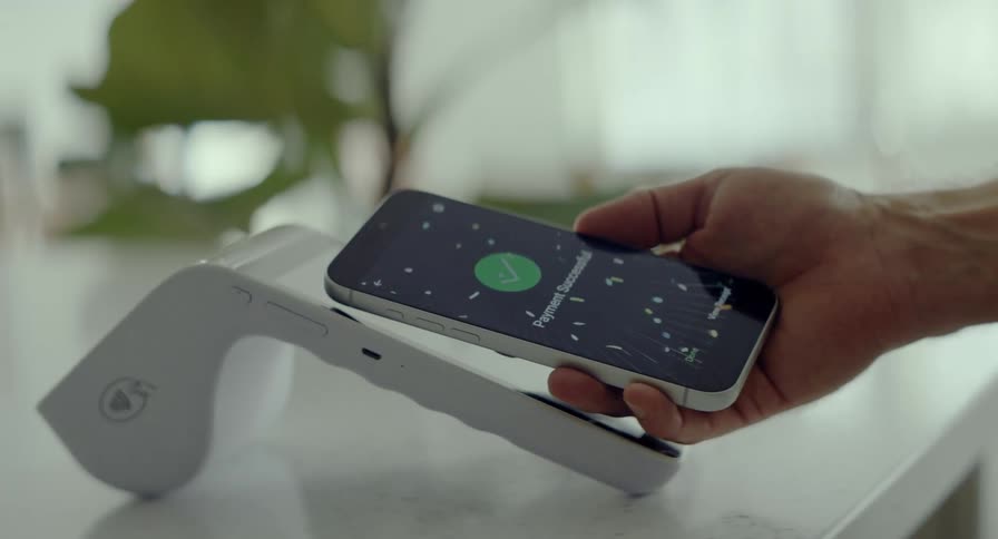 Close-up of a contactless smartphone payment with a dynamic spinning visual effect as the transaction is successfully completed