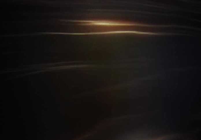 Mysterious light reflections undulate and glow, creating a hypnotic and moody visual effect