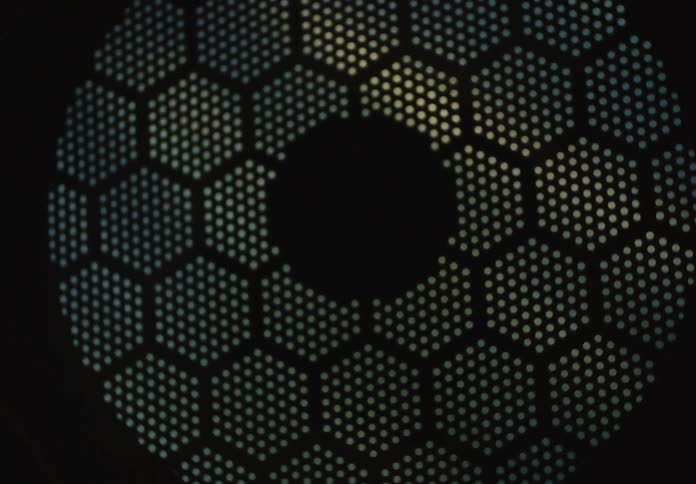 Hypnotic rotation of a futuristic honeycomb mesh pattern with shimmering light