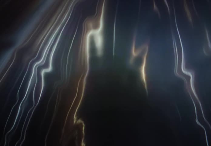 Soft, glowing lines of light in shades of gold and white flow and shimmer like liquid silk against a dark void