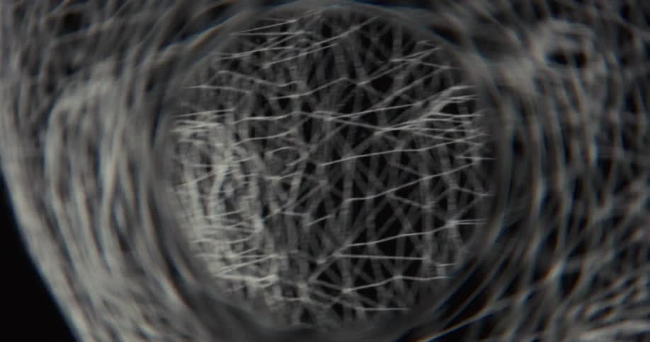 Close-up of a CGI wireframe head deconstructing and vanishing in a surreal, swirling vortex on a black background