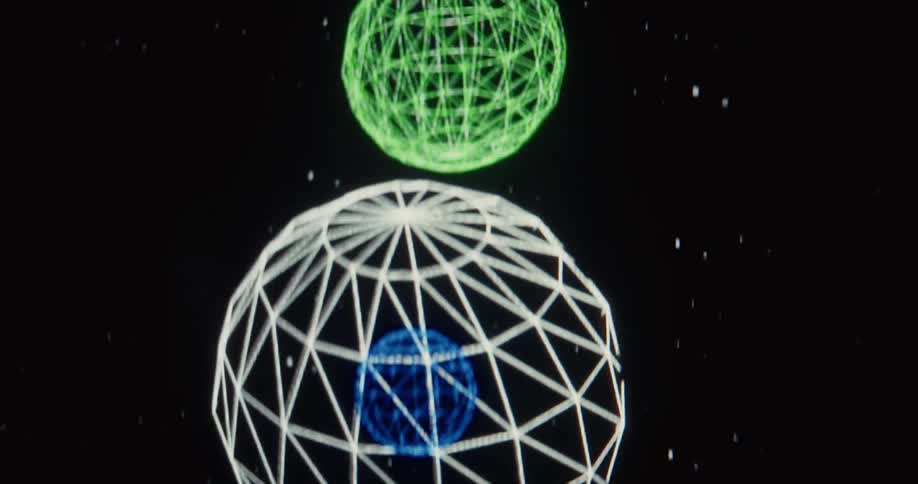A close-up of a computer animation showing multi-colored wireframe spheres floating downwards